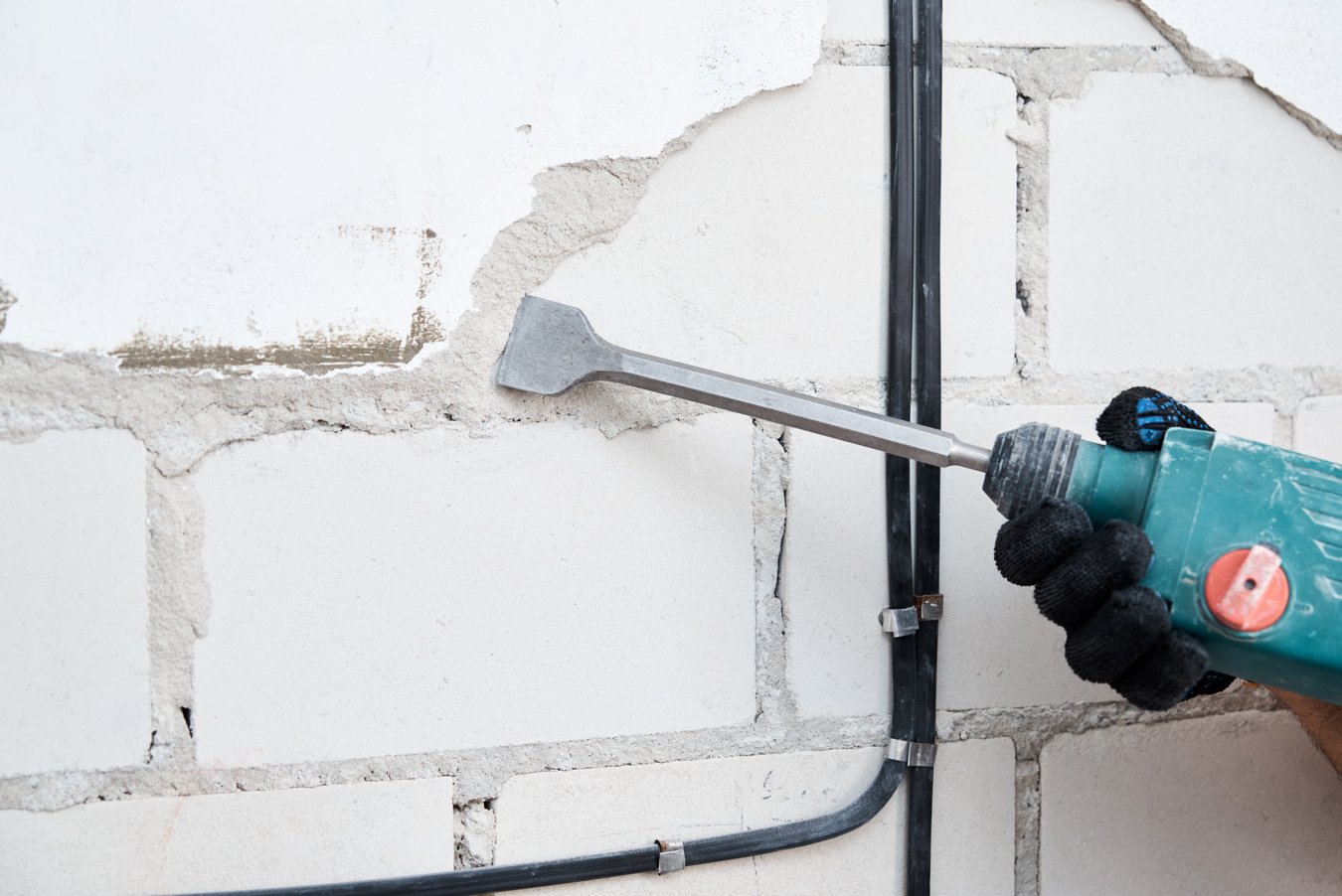 Demolition Hammer Removing Stucco from Wall